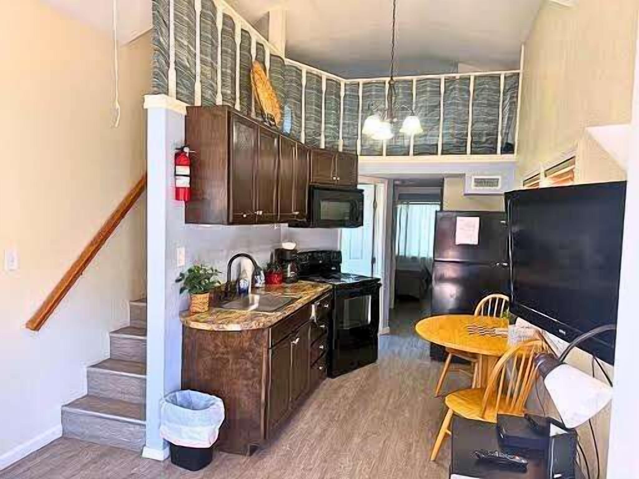 Een koelkast, een magnetron, een oven, eettafels