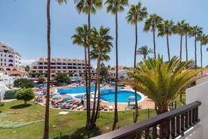 A resort with a central pool surrounded by palm trees and sun loungers. - Parque Santiago II 87 - Two Bed (Playa de la Américas)