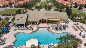 Ein Resort mit einem zentral gelegenen Pool, Liegebereichen und einem Parkplatz.