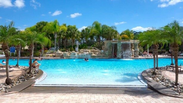Ein Pool mit Palmen und einem Wasserfall.