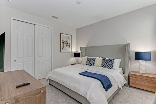 A bedroom with a bed, bedside tables, a nightstand, a TV, a wardrobe, and a painting on the wall. - Harry Potter | Harley Game Loft | Near Disney 1787 (Kissimmee)