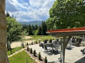 Un patio al aire libre con asientos y vistas a un paisaje montañoso.