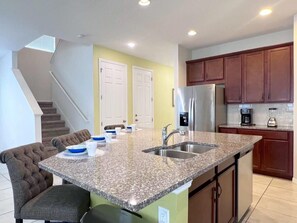 A kitchen with granite countertops, stainless steel appliances, and wooden cabinets.