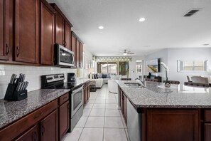 A modern kitchen with granite countertops, stainless steel appliances, and wooden cabinets.