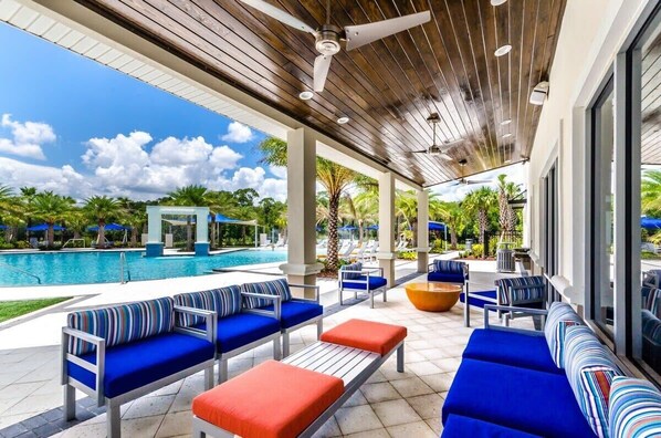 Un espacio al aire libre techado con asientos, una piscina y vistas a la piscina.