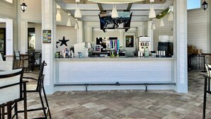 Un restaurante con mostrador, luces colgantes y una pizarra de menú.
