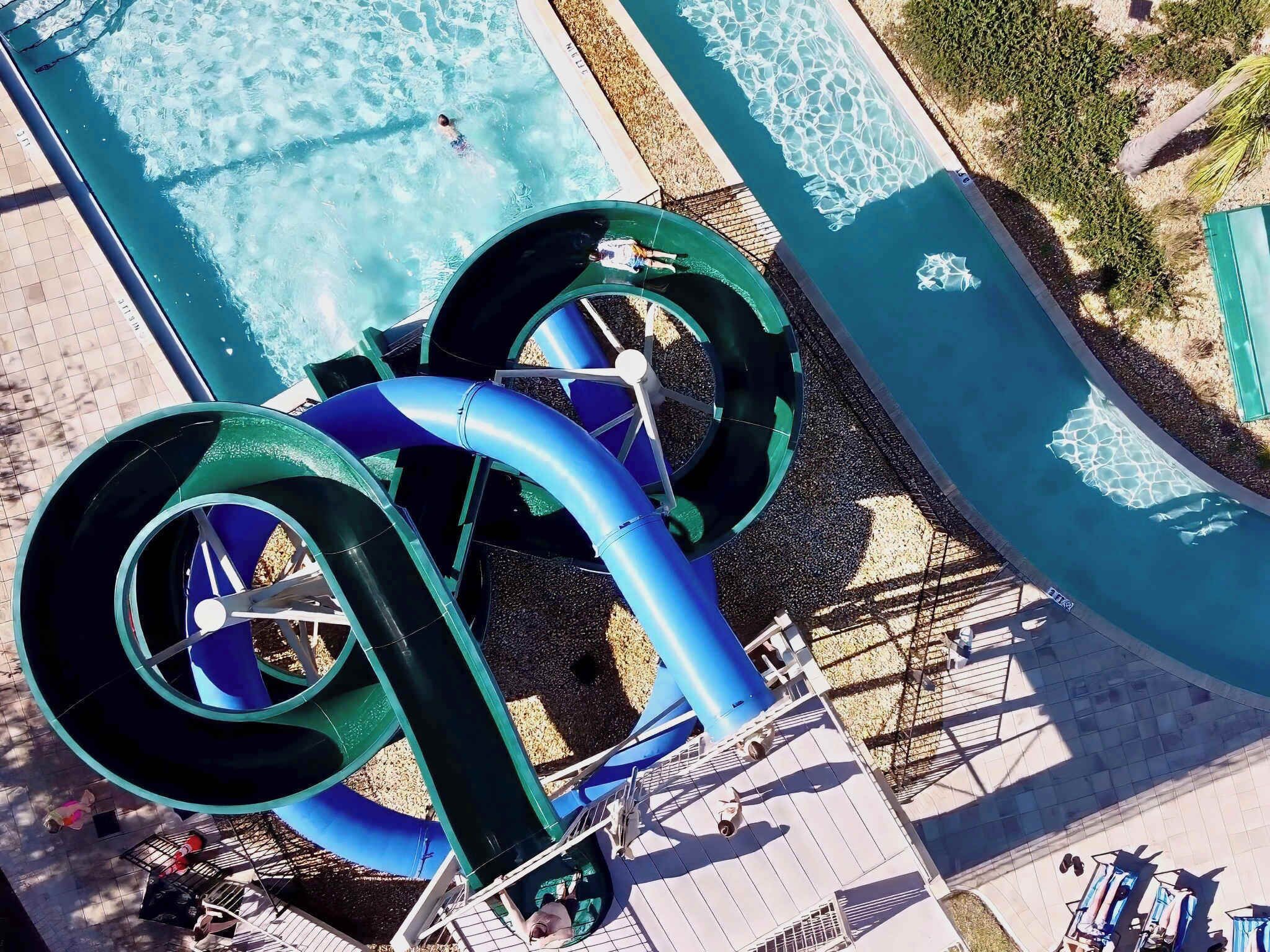A water park with two large water slides and a pool.