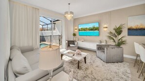 Ein modernes Wohnzimmer mit einer Couch, einem Couchtisch, einem Fernseher und Meerblick.