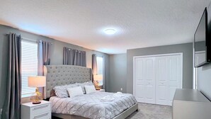 A bedroom with a bed, nightstands, a dresser, a wardrobe, and a television on the wall. - Star Wars | Avengers | Pool | Resort | Disney 4544 (Kissimmee)