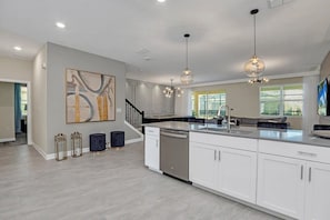 Enjoy meals in the spacious kitchen with a central island, stainless steel appliances, and a dining area offering a view of the outdoors.