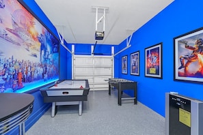 A room with blue walls, a pool table, foosball table, and movie posters. - Lakeview! Bid Screen! Resort 6 mi 2 Disney! 4795 (Kissimmee)