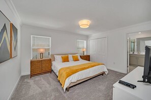 A bedroom with a bed, bedside lamps, a TV, and a carpeted floor. - Value! Clean! Lazy River-Resort 6 mi 2 Disney-4228 (Kissimmee)