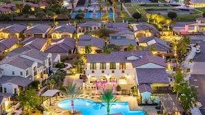 A residential area with houses, a swimming pool, and a well-lit driveway. - Desert Serenity | Pool, Spa, BBQ, Near Courses (La Quinta)