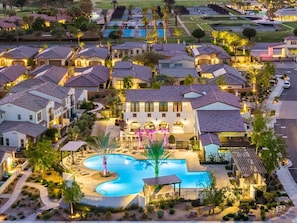 A residential area with houses, a swimming pool, and a well-lit driveway. - Desert Serenity | Pool, Spa, BBQ, Near Courses (La Quinta)