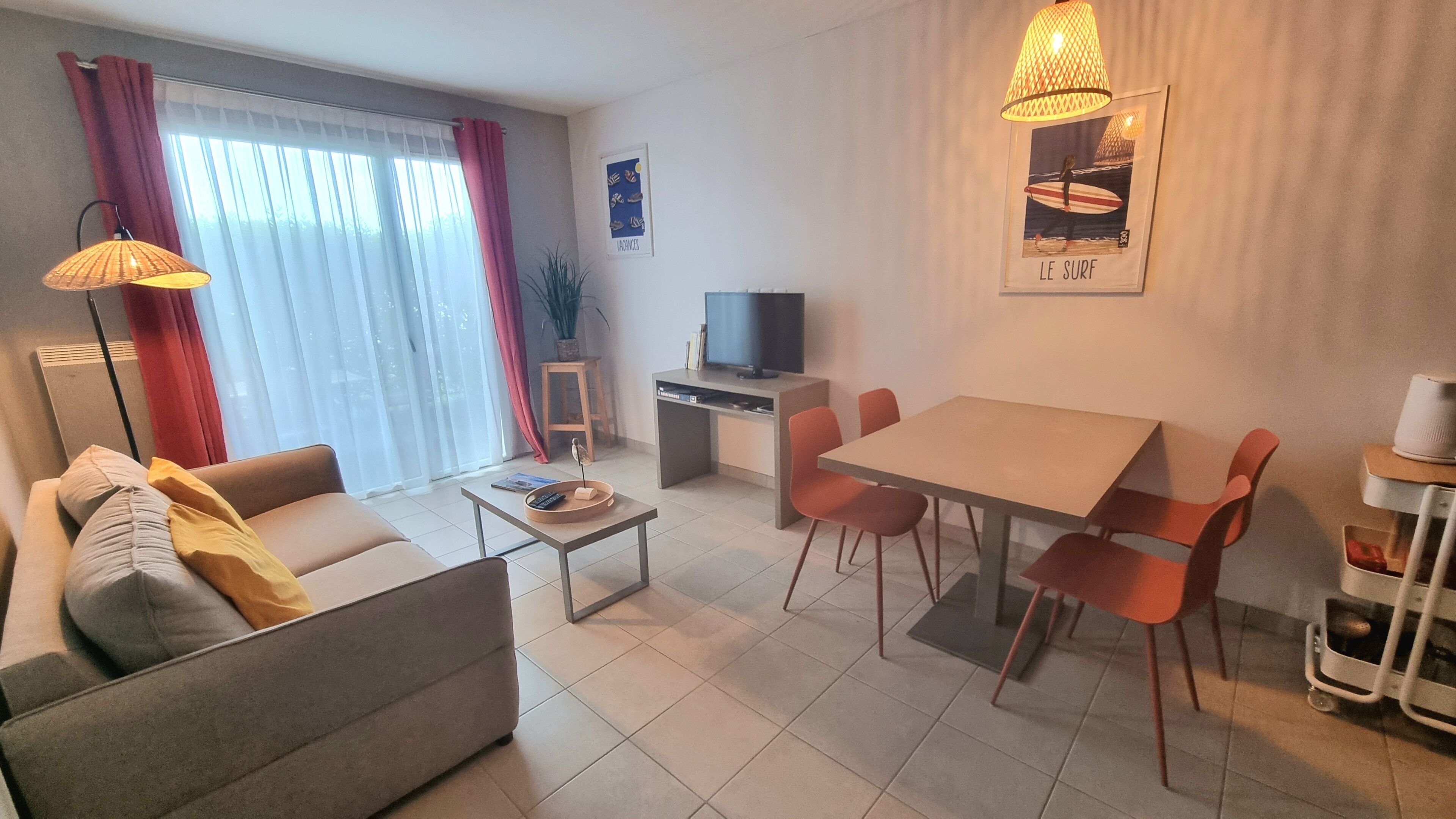 A modern living room with a sofa, coffee table, TV, and dining area with chairs.