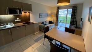 Una cucina moderna con zona pranzo, divano e vista sull'esterno.