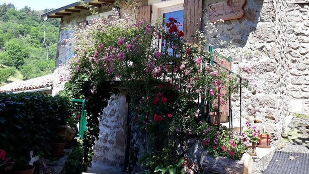 Un bâtiment rustique en pierre, doté d’une porte en bois et d’une enseigne indiquant « Gîte de Provence ».