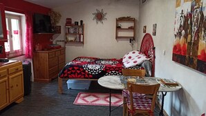 A bedroom with a bed, a desk, a chair, a TV, and a painting on the wall. - Gîte du Château de Retourtour (lamastre)