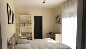 A bedroom with a bed, a bookshelf, a desk, and a chair. - Gite 4 Personnes Terrasse Jardin Piscine (aspiran)