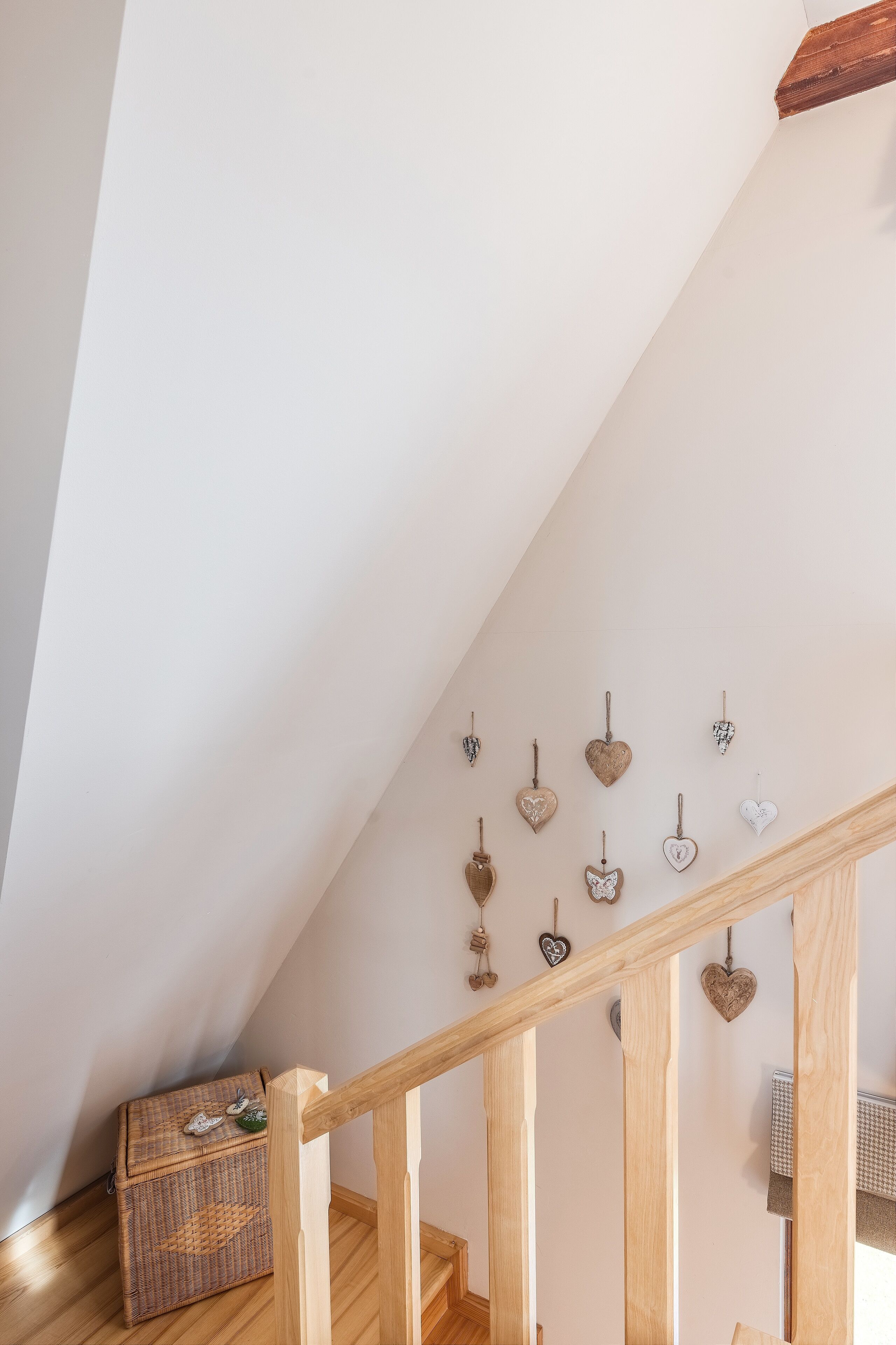 A wooden staircase with a woven basket at the bottom.
