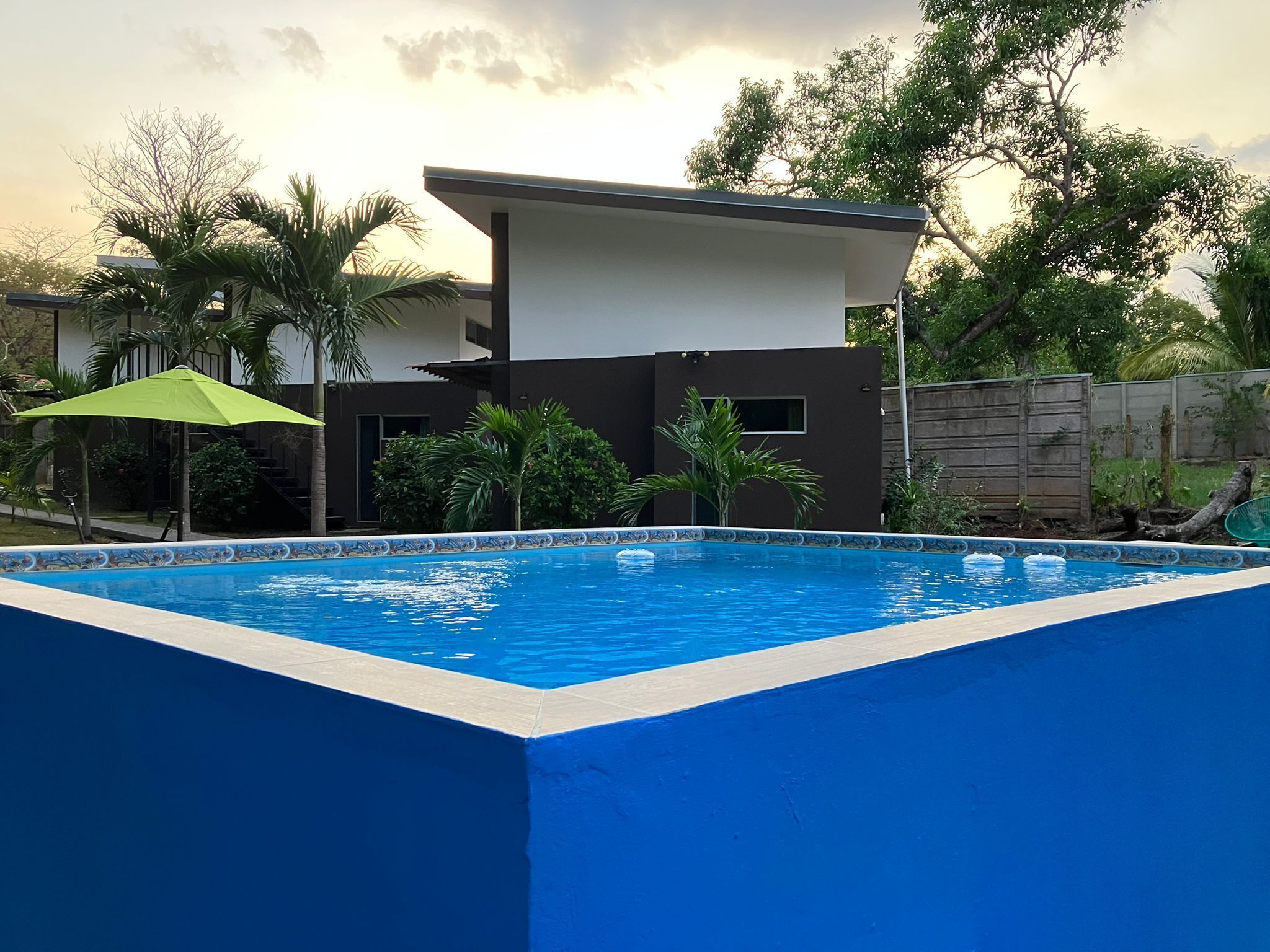 A rectangular swimming pool with a blue interior and a white edge, surrounded by a blue wall.