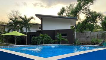 A rectangular swimming pool with a blue interior and a white edge, surrounded by a blue wall.