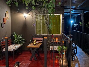 A cozy outdoor dining area with wooden tables and benches, surrounded by plants and a railing. - Nueva Villa Paraiso (Lagunillas)