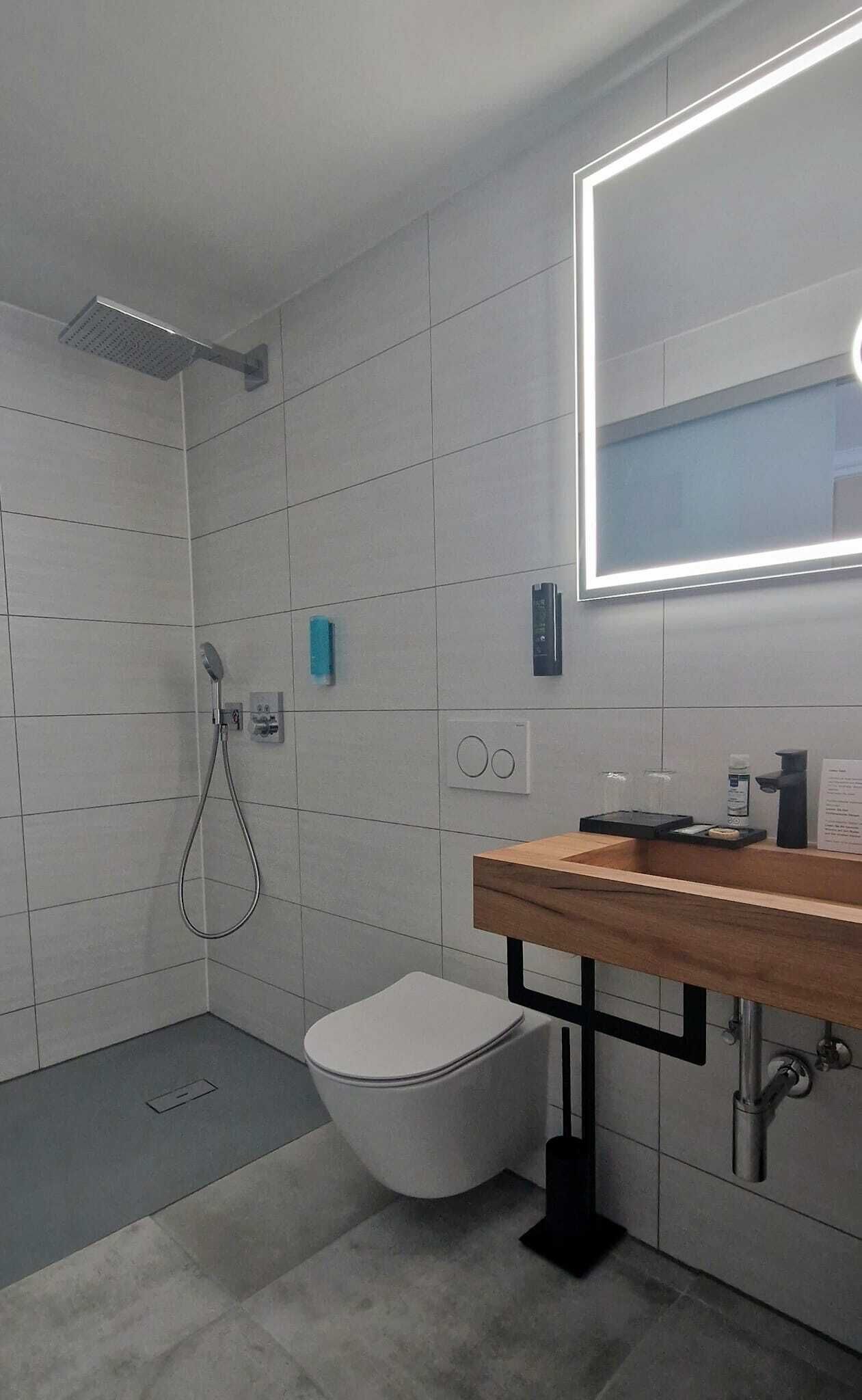 A modern bathroom with a shower, toilet, and vanity.