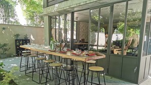 An outdoor dining area with a long table set for six, surrounded by stools. - Villa Piscine, Jardin Arboré, Proche Centre Ville (Montélimar)