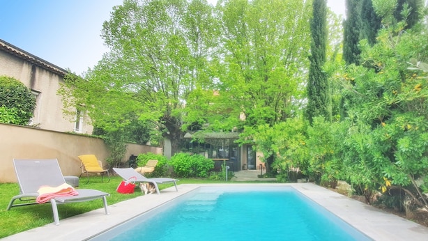 A rectangular swimming pool with two lounge chairs and a red bag on the left side. - Villa Piscine, Jardin Arboré, Proche Centre Ville (Montélimar)