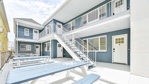 Un edificio de varios pisos con terraza y una escalera.