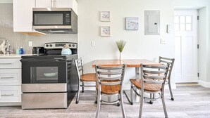 Een moderne keuken met roestvrijstalen apparatuur, een houten eettafel en metalen stoelen.