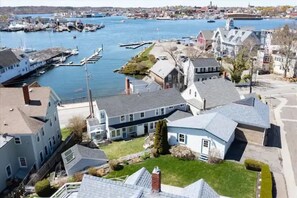 A coastal town with a marina, houses with gabled roofs, and a clear view of the water. - 3BR Harborside Home • Gloucester+Rockport • Ocean View (Gloucester)