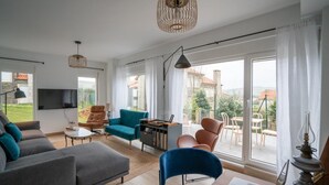 A modern living room with a sofa, chairs, a coffee table, and a laptop on a desk. - Montealmar Galizano Somo (ribamontan al mar)