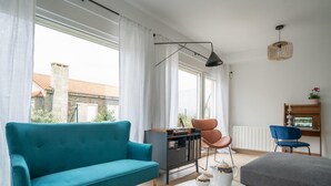 A modern living room with a teal sofa, a grey sofa, a coffee table with cups and a teapot, a bookshelf, and a hanging light fixture. - Montealmar Galizano Somo (ribamontan al mar)