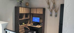 A home office setup with a desk, computer, and storage cabinets.