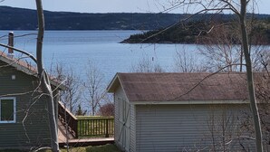 A lakeside property with a small shed, a house, and a dock extending into the water. - Explore and relax with ocean views in Charlottetown Bonavista Bay Newfoundland!  (Charlottetown)