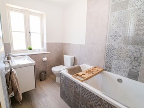Uma casa de banho moderna com lavatório, sanita e banheira.