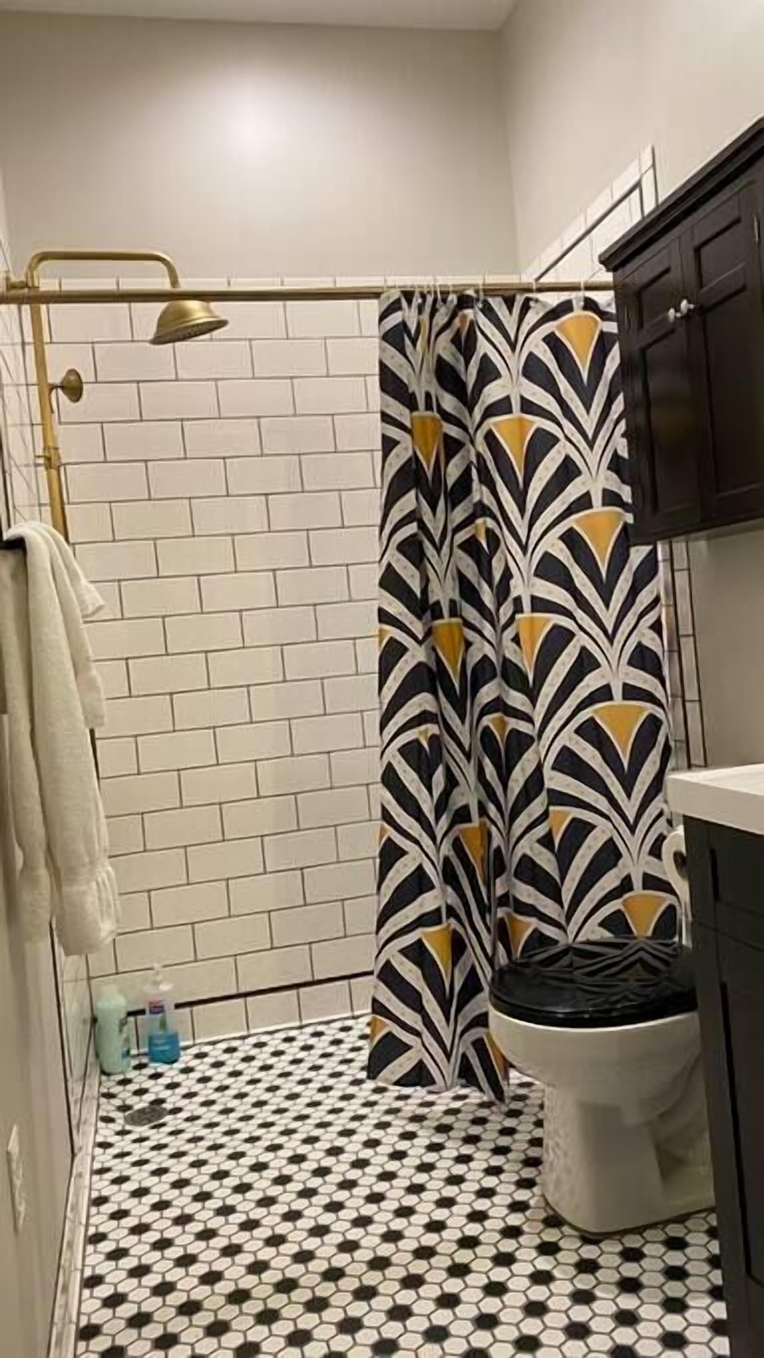 A bathroom with a shower, toilet, and sink.