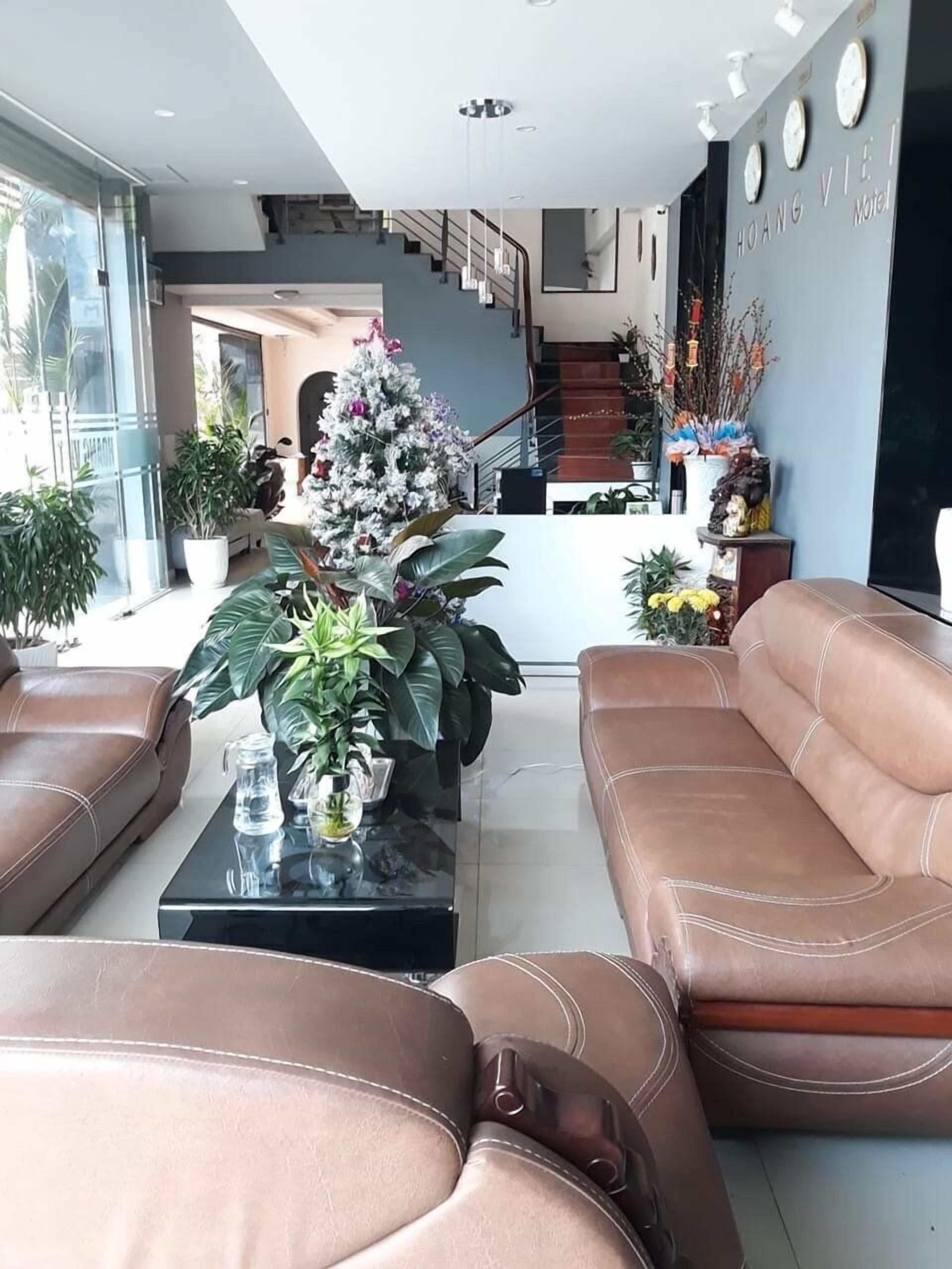 Un salon moderne avec des canapés en cuir, une table basse en verre et des plantes en pot.