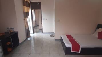 Ein Hotelzimmer mit zwei Betten, einem Schreibtisch und einem Kleiderschrank.