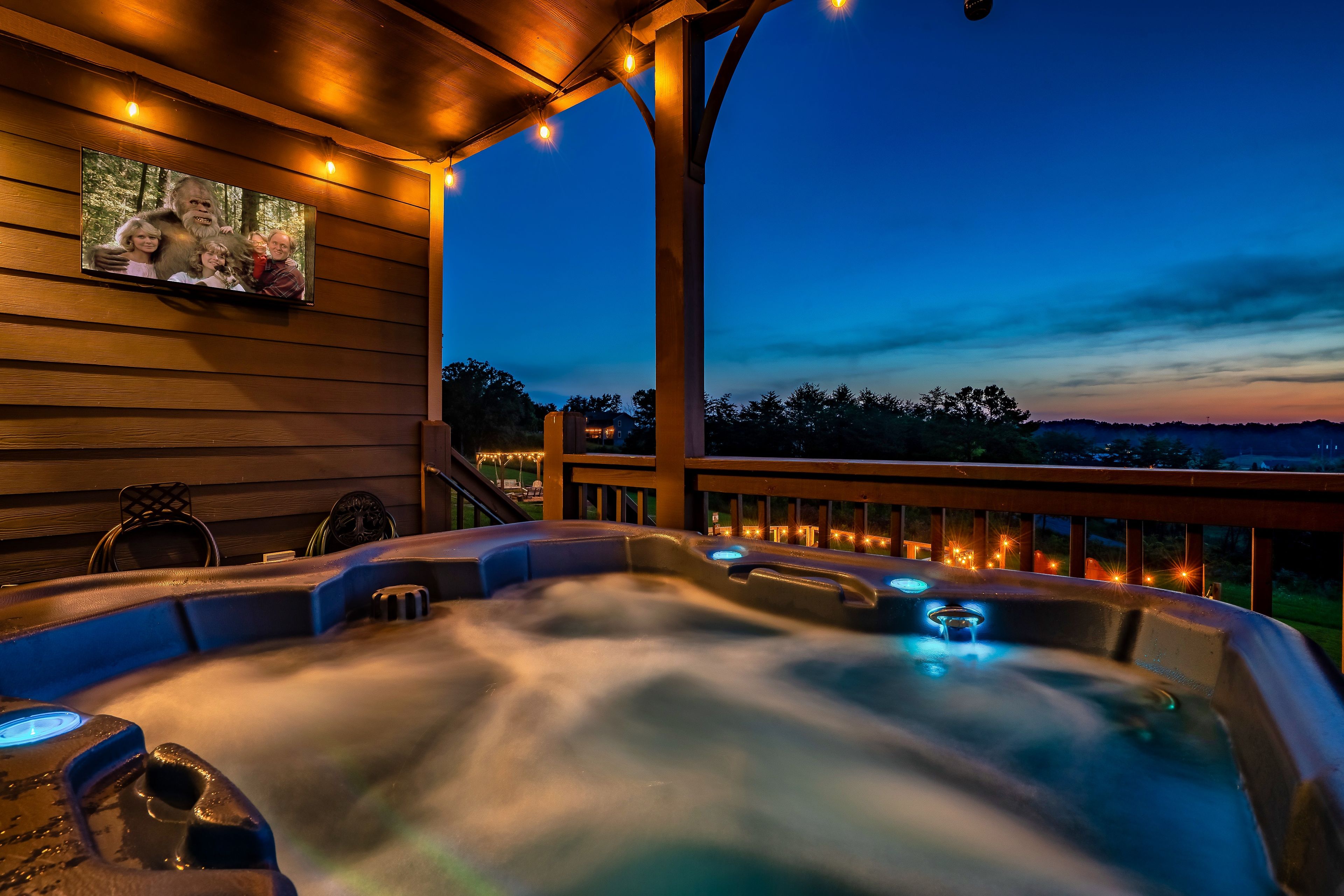 Ein Whirlpool mit Holzterrasse und Blick auf einen Sonnenuntergang.