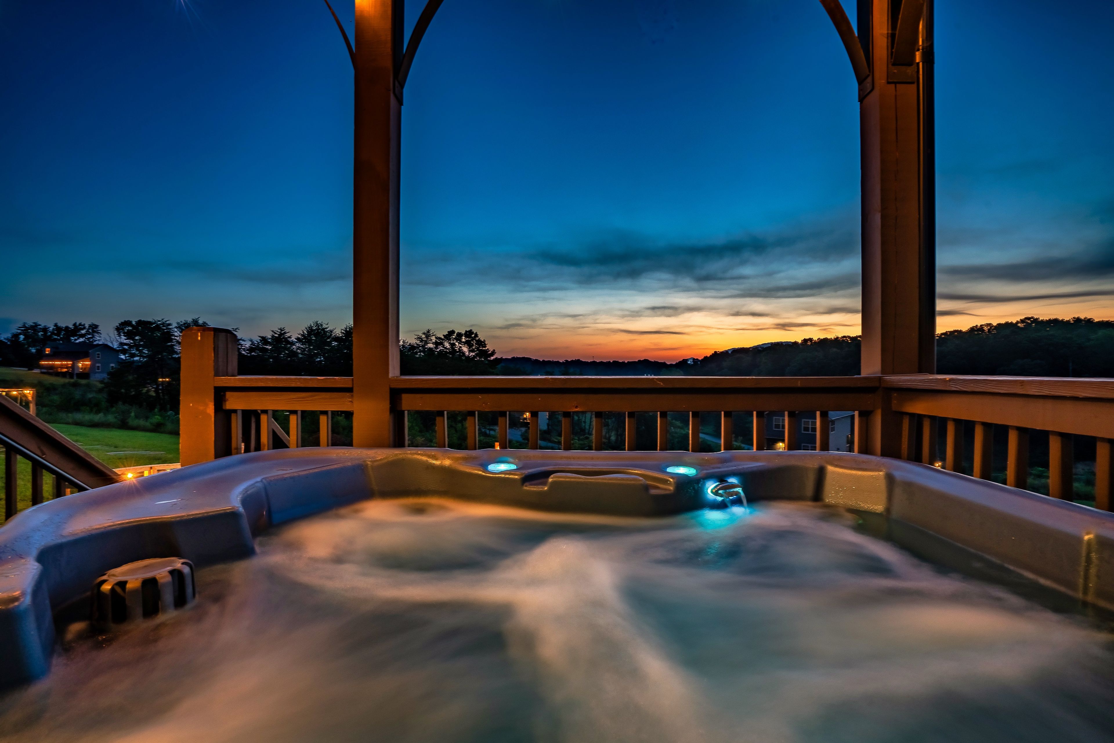 Un jacuzzi con vistas a la puesta de sol y las colinas.