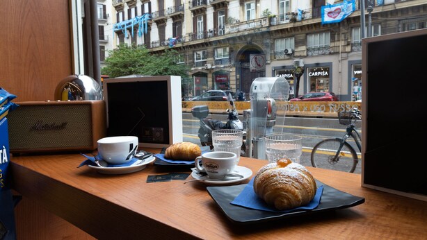 A table with a croissant, a cup of coffee, and a glass of water. - CIVICO 237 (Naples)