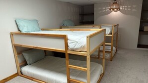A room with bunk beds, a carpeted floor, and a hanging light fixture. - West World (Beaver Dam)