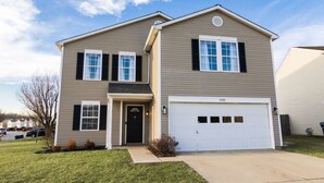 A two-story house with a garage, a front door, and a driveway. - Acoustic Oasis- RUOFF Music & POOL TABLE sleeps 10 (Noblesville)