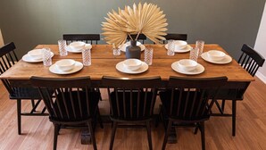 A dining table set with white plates, bowls, and glassware, surrounded by black chairs. - Acoustic Oasis- RUOFF Music & POOL TABLE sleeps 10 (Noblesville)