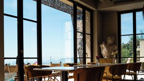 A spacious dining area with large windows, a sculpture, and a view of the landscape. - Tenuta Zamparina (Montignoso)