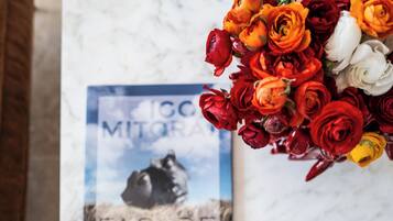 Una mesa de mármol con un ramo de flores y un retrato enmarcado de un perro con correa.