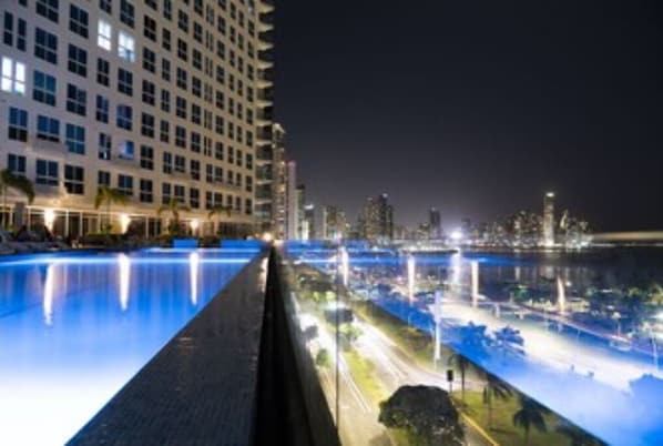 A nighttime view of a hotel with a pool overlooking a cityscape. - Studio Apartment - Ocean View (Panamá)
